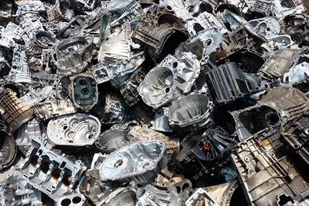 Imagem que mostra sucata de aluminio com blocos de motores caixas de cambio